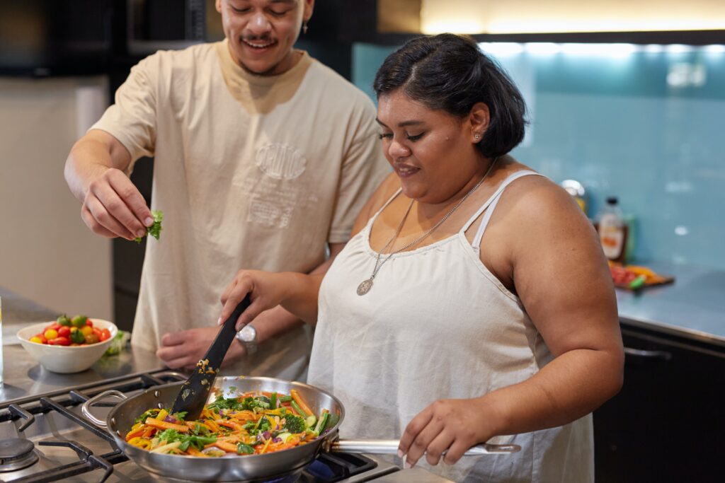 Image of a man and a woman cooking - Rendé - conversation starters and date ideas