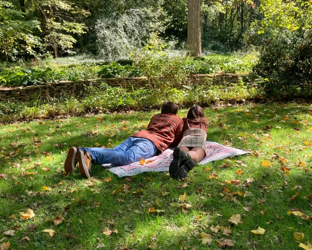 Image of a man and a woman sitting on a picnic blanket having a date 1 - Rendé - conversation starters and date ideas