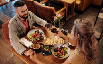 Man and woman at a dinner table holding hands